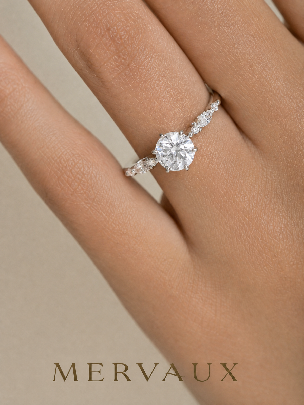 A round brilliant with marquise side stones worn on a hand, at the scale a stone is actually judged.