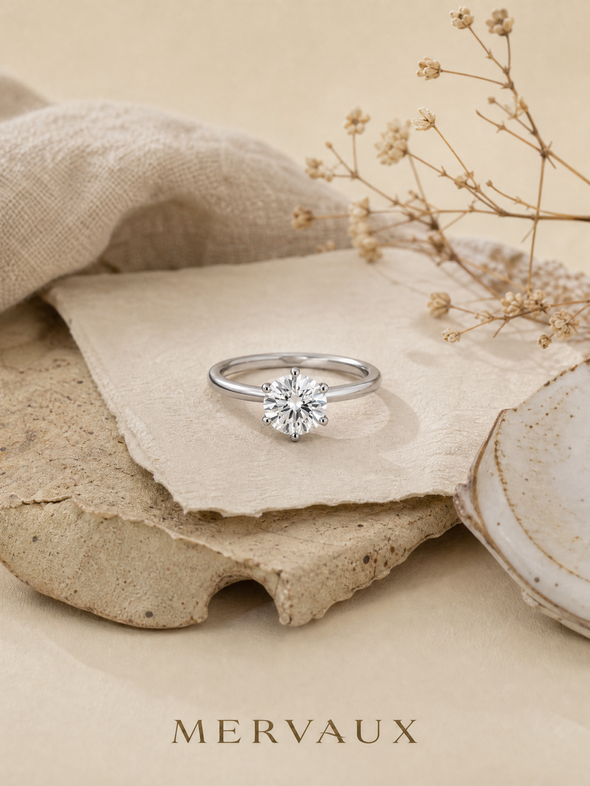 A platinum solitaire resting on stone and linen, the first piece in a collection that is built slowly.
