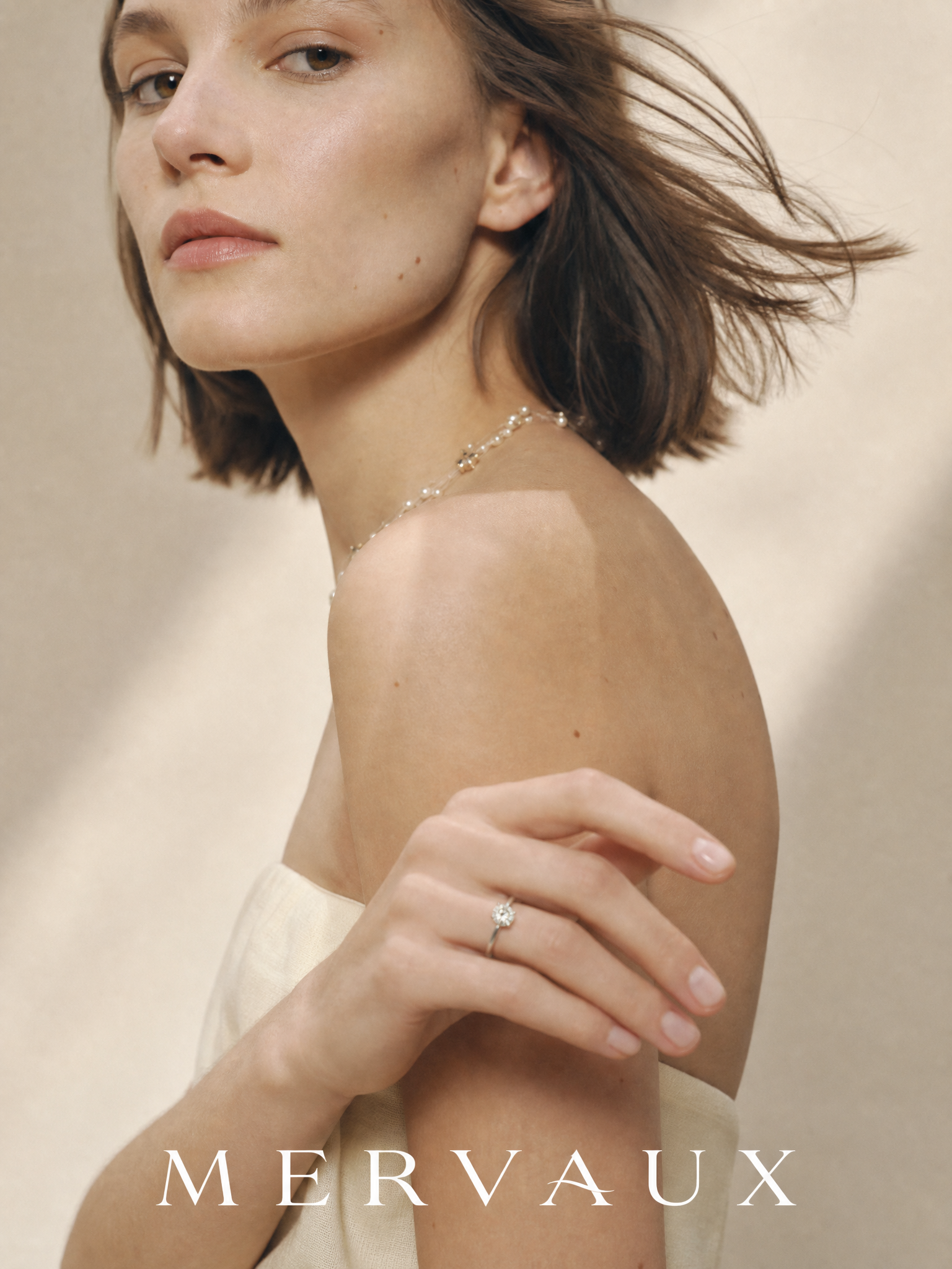 A platinum solitaire on a hand in motion, caught mid-gesture rather than presented to the camera.