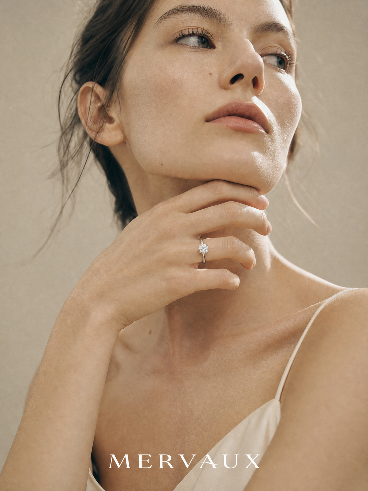 A hand at the neck, where the length of a chain is decided against the collarbone rather than by a number.