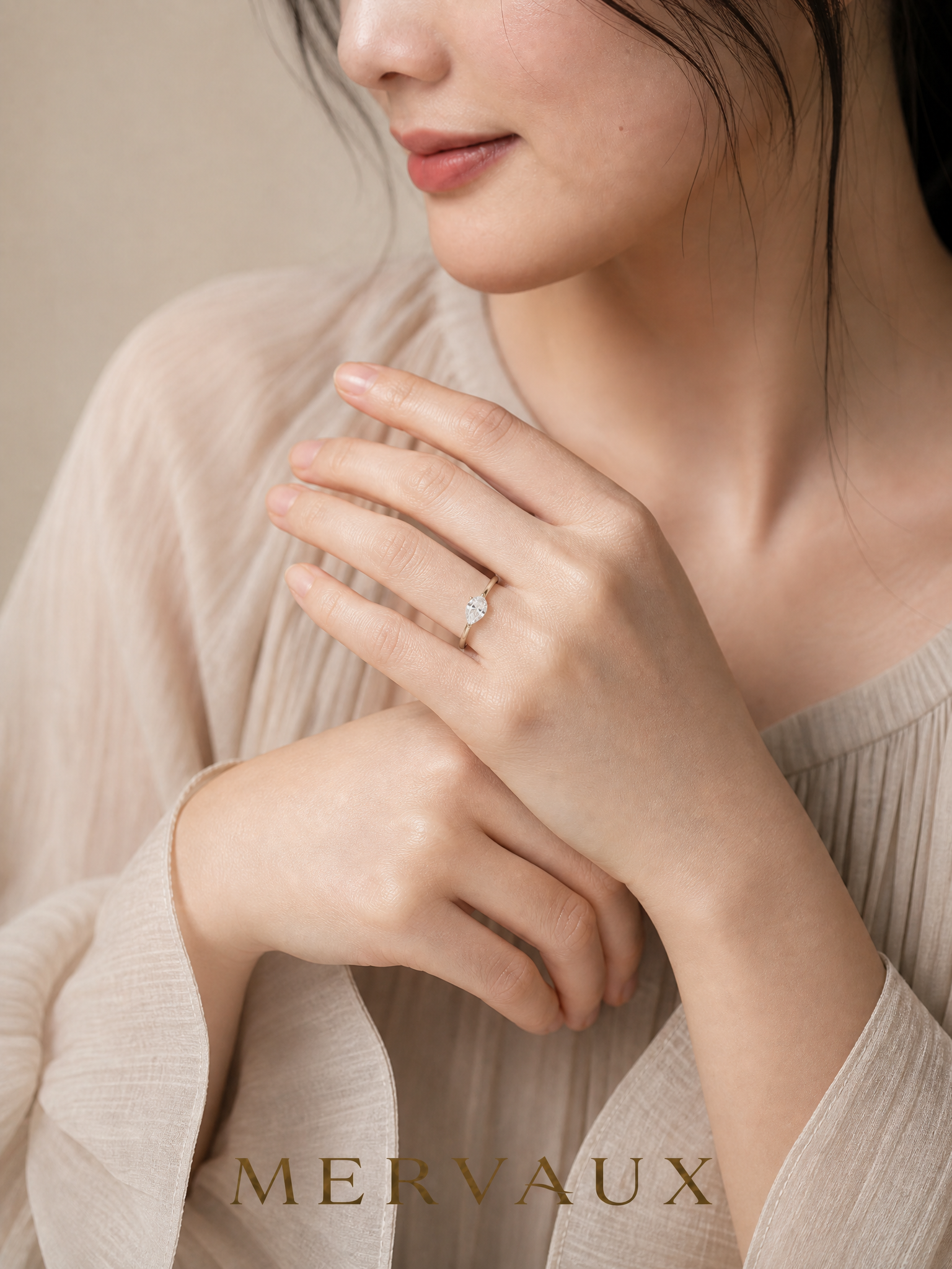 MERVAUX two-tone pear diamond ring worn, hands at collarbone