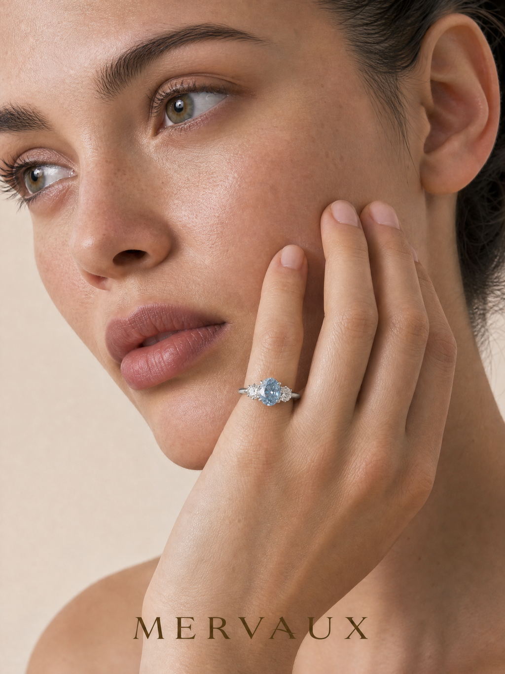 MERVAUX blue oval three-stone diamond ring worn, portrait close-up