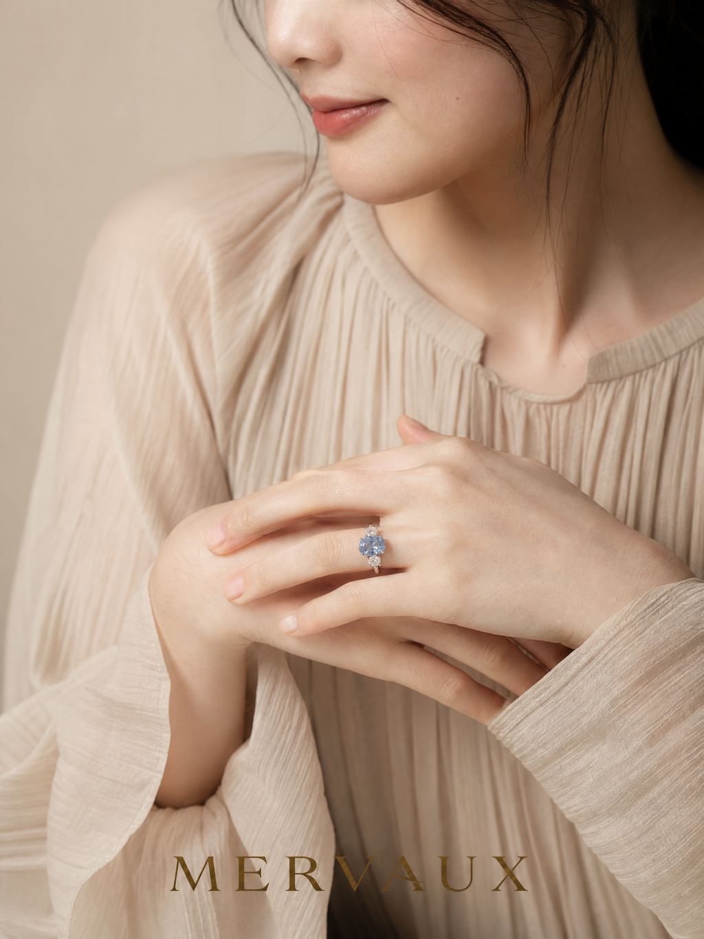 MERVAUX blue oval three-stone diamond ring worn, hands folded